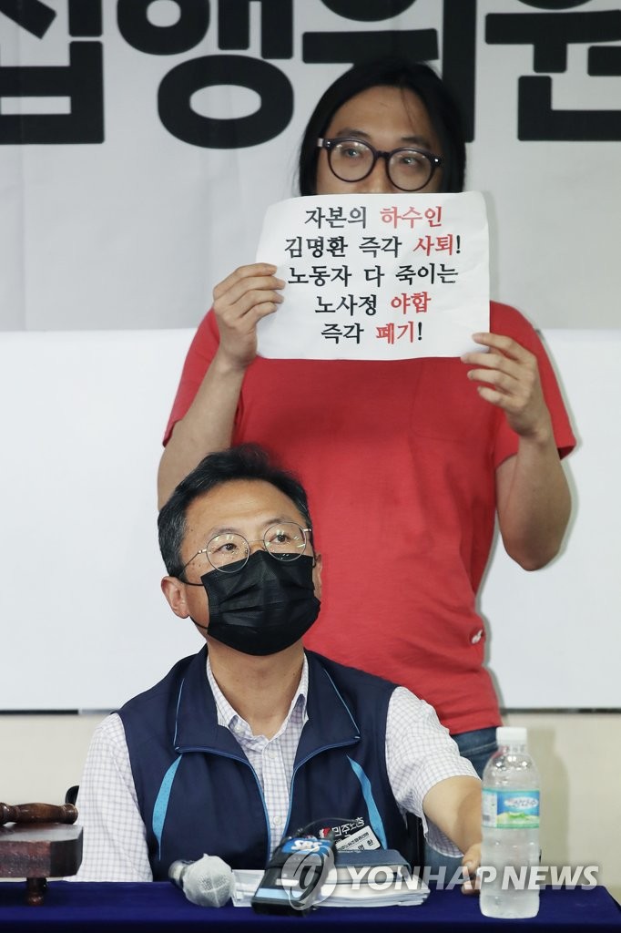김명환 민주노총 위원장과 노사정 합의 반대 손팻말 든 조합원