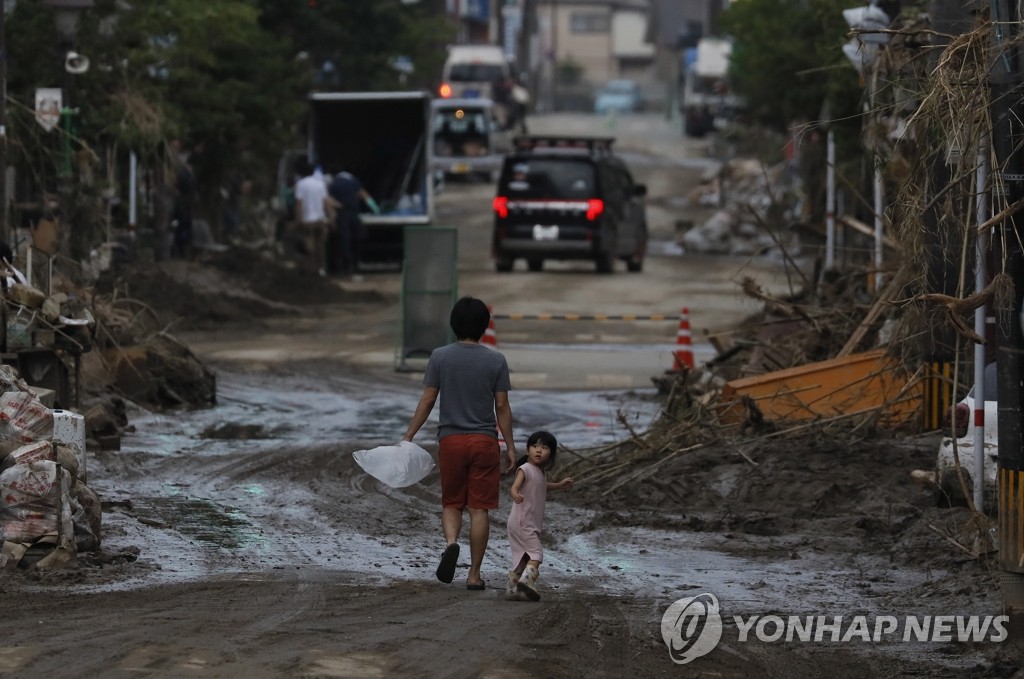 폭우로 엉망이 된 길 걷는 일본 아빠와 어린이