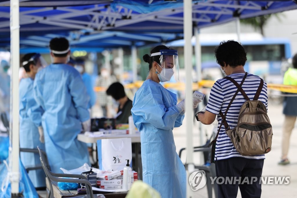 Medical staff members carry out new coronavirus tests at a makeshift clinic in southern Seoul on Aug. 10, 2020. (Yonhap)