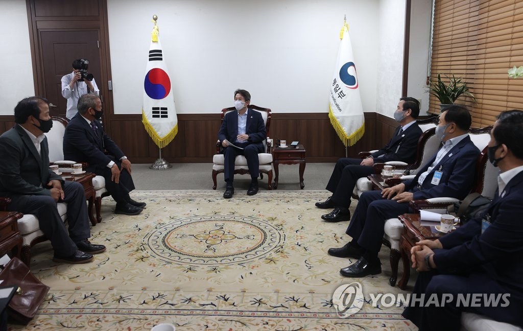 Unification Minister Lee In-young (C), South Korea's point man on inter-Korean relations, talks with a group of businesspeople who have factories in the suspended inter-Korean industrial park in the North Korean border town of Kaesong during their meeting at the government complex in Seoul on Aug. 21, 2020. (Yonhap)