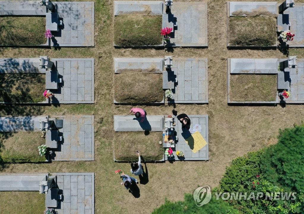 Members of a family pay their respects at an ancestral grave site in a memorial park in Incheon, west of Seoul, on Sept. 13, 2020, well ahead of the upcoming Chuseok fall harvest holiday. (Yonhap)