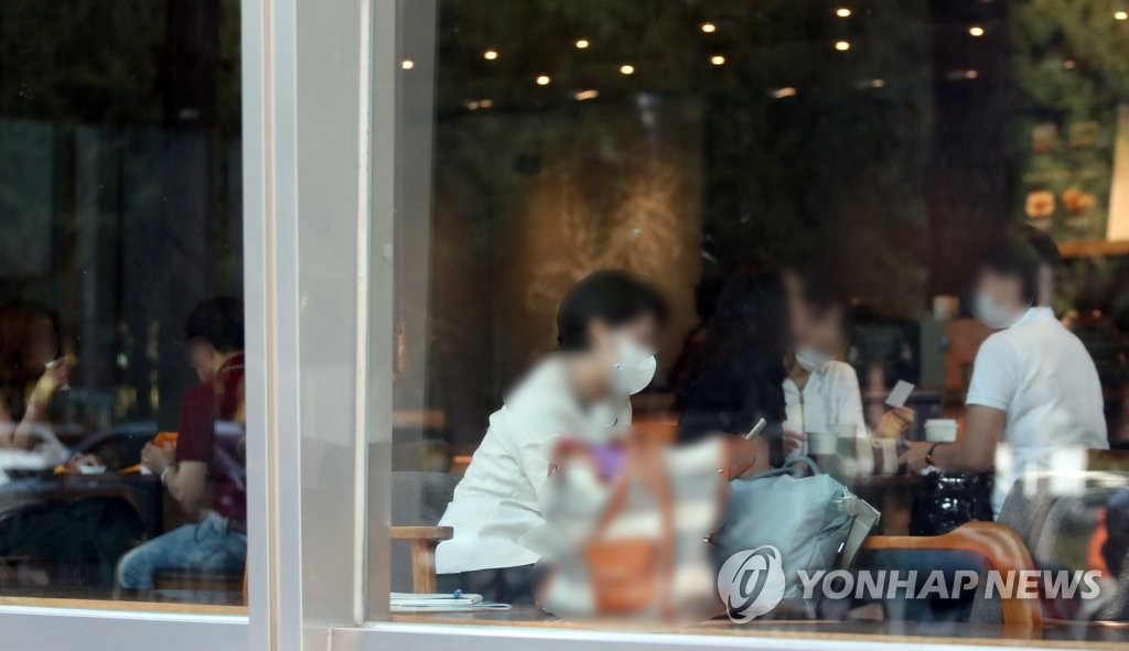 首都圏での「社会的距離の確保」措置が第２段階に引き下げられたことを受け、通常営業を再開したソウル市内のカフェ＝１４日、ソウル（聯合ニュース）