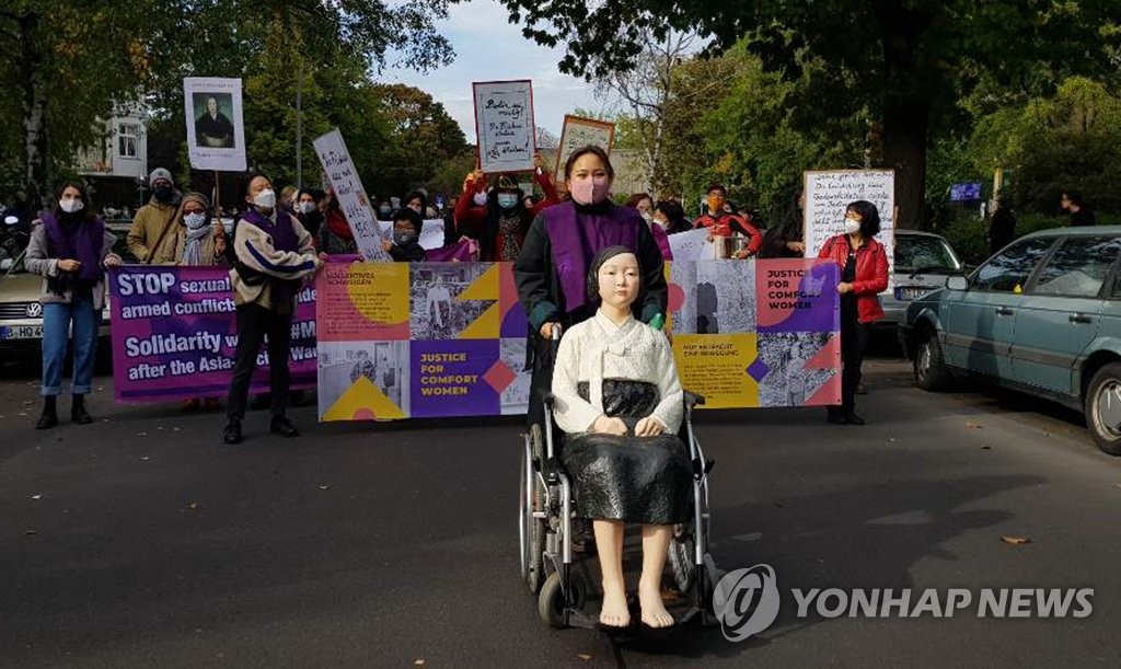 Activists and citizens march in Berlin on Oct. 13, 2020, calling for the withdrawal of a district office's order to remove the Statue of Peace, which symbolizes Korean victims of Japan's wartime sexual slavery. (Yonhap)