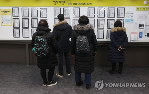 People stand in line to attend a presentation on how to receive unemployment benefits at a labor welfare center in Seoul on Jan. 13, 2021. (Yonhap)