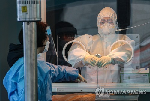 Medical officials prepare to carry out COVID-19 tests at a makeshift clinic in Seoul on Jan. 14, 2021. (Yonhap)