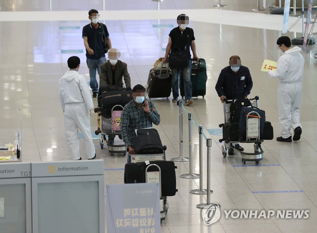 Travelers walk in an arrival hall of Incheon International Airport, west of Seoul, on April 6, 2021. (Yonhap)