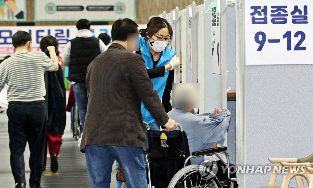 A senior in a wheelchair gets ready for inoculation with Pfizer's COVID-19 vaccine at a vaccination center in southern Seoul on April 17, 2021, in this photo provided by the Dongjak Ward Office. (PHOTO NOT FOR SALE) (Yonhap)