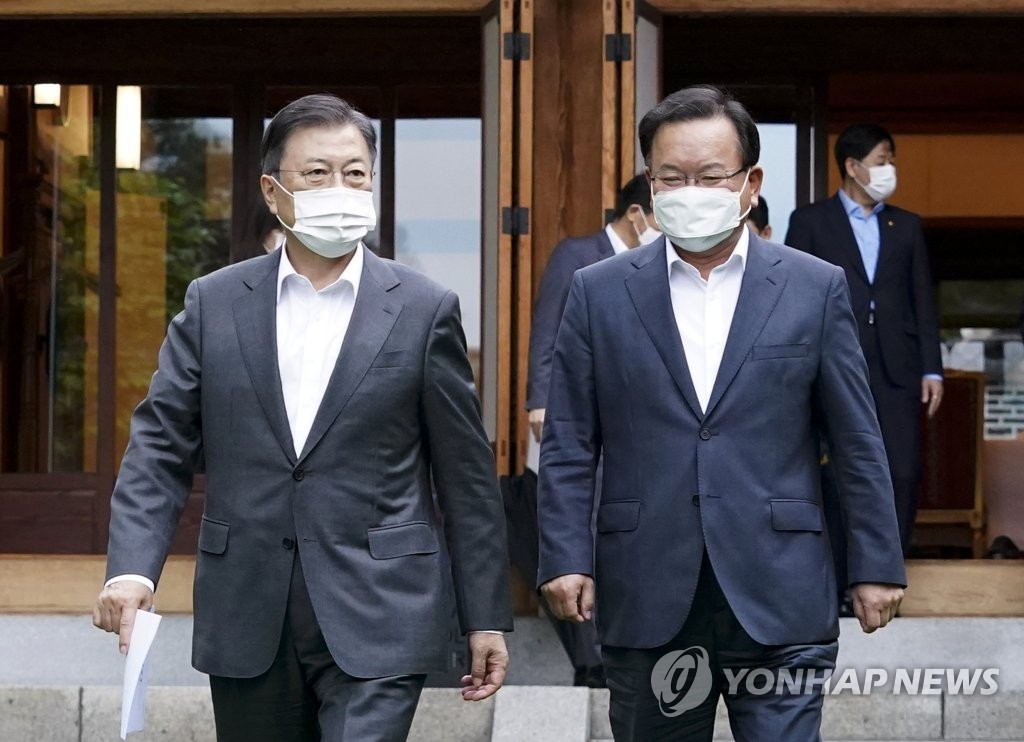 President Moon Jae-in (L) and Prime Minister Kim Boo-kyum walk together at a complex at Cheong Wa Dae in Seoul after holding their first regular weekly meeting on May 17, 2021, since Kim's inauguration last week. (Yonhap) 