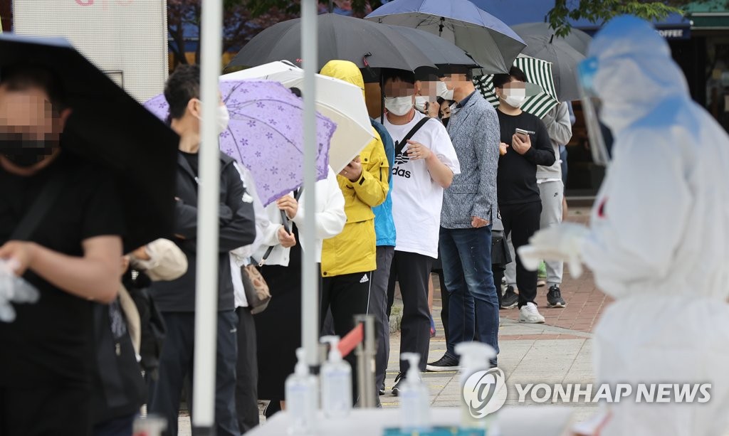 부슬비 내리는 아침, 검사 기다리는 시민들
