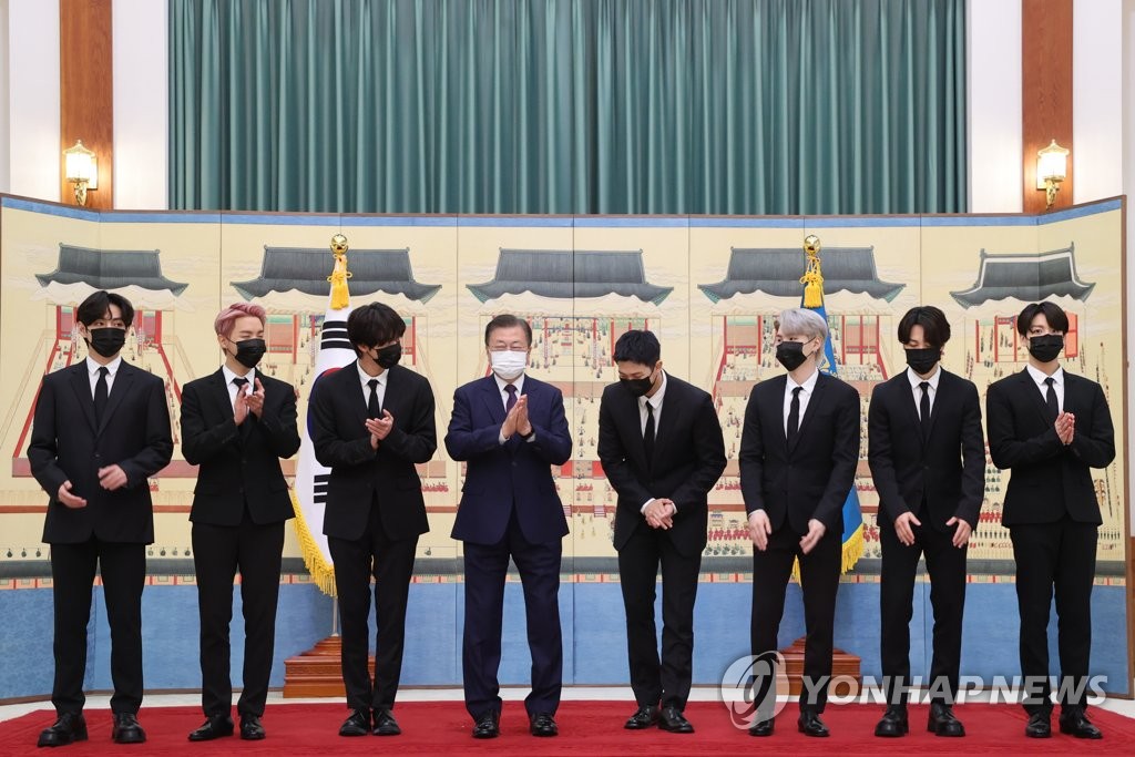 青瓦台で記念撮影を行う文大統領（左から４人目）とＢＴＳ＝１４日、ソウル（聯合ニュース）