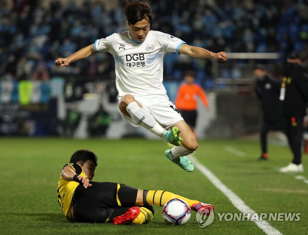 An Yong-woo of Daegu FC (R) avoids a tackle by Kim Tae-hyun of Jeonnam Dragons during the opening leg of the FA Cup final at Gwangyang Football Stadium in Gwangyang, South Jeolla Province, on Nov. 24, 2021. (Yonhap)