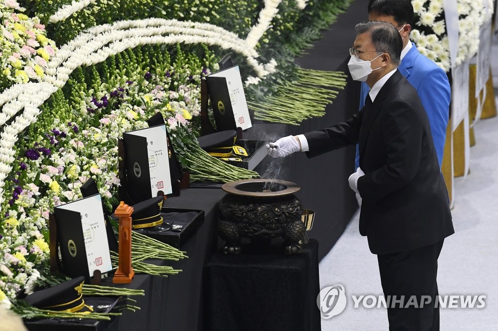 South Korean President Moon Jae-in pays respect to three firefighters who died while battling a fire, during a send-off ceremony held in Pyeongtaek, 70 kilometers south of Seoul, on Jan. 8, 2022. The fire broke out at a warehouse in the city on Jan. 5. (Pool photo) (Yonhap)