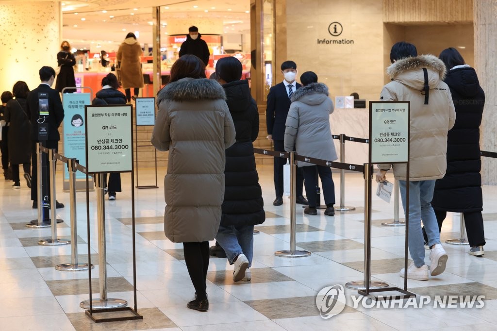 Visitors wait in line to get their vaccine certifications checked at the entrance of a department store in Seoul, in the Jan. 17, 2022, file photo. (Yonhap)