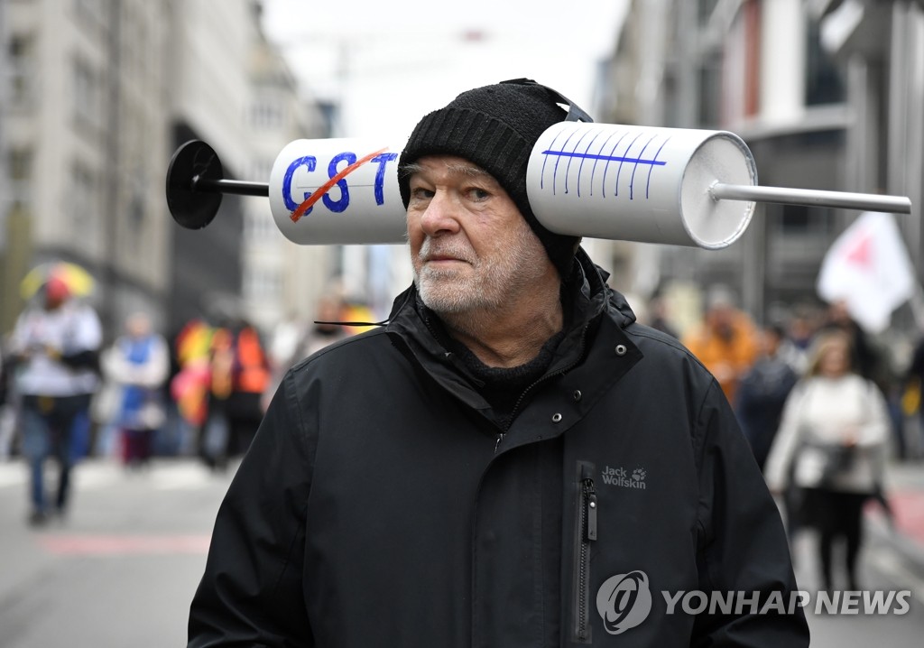 주사기 모형 달린 모자 쓰고 코로나 방역 항의하는 벨기에인