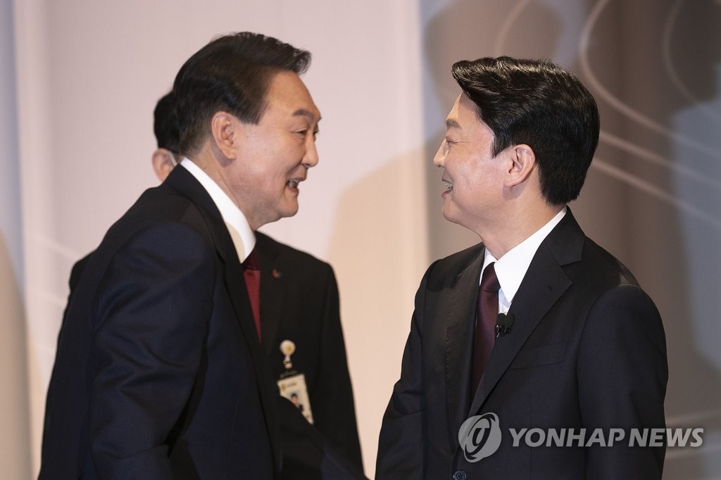 Yoon Suk-yeol (L), the presidential candidate of the main opposition People Power Party (PPP), greets Ahn Cheol-soo, the presidential candidate of the minor opposition People's Party, ahead of a presidential debate at SBS in Seoul on Feb. 25, 2022. (Yonhap)
