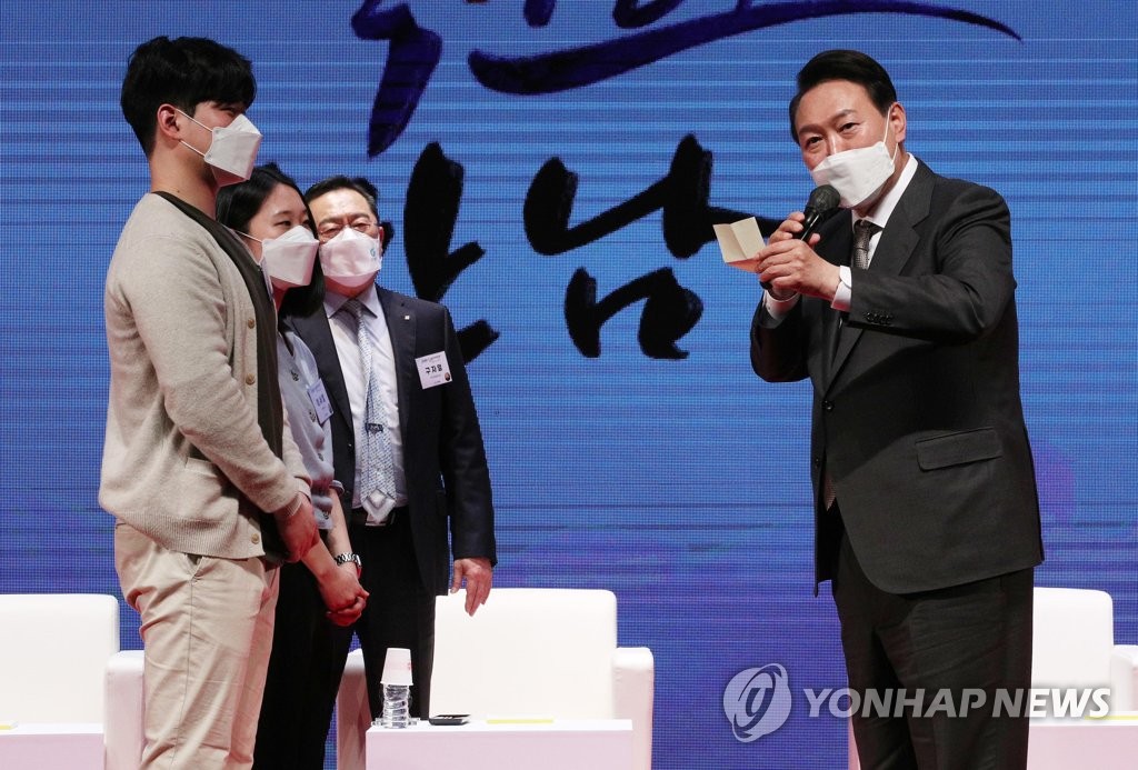 President-elect Yoon Suk-yeol (R) reads a message from young traders during a Korea International Trade Association (KITA) event in Seoul on March 31, 2022. (Pool photo) (Yonhap)