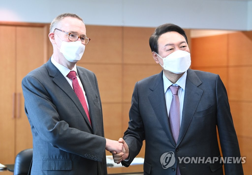 Le président élu Yoon Suk-yeol et l'ambassadeur britannique en Corée du Sud, Colin James Crooks, échangent une poignée de main le vendredi 15 avril 2022 au bureau du comité de transition du pouvoir. (Pool photo)