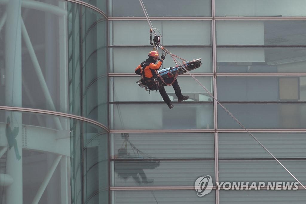 로프로 부상자 이송하는 소방관들