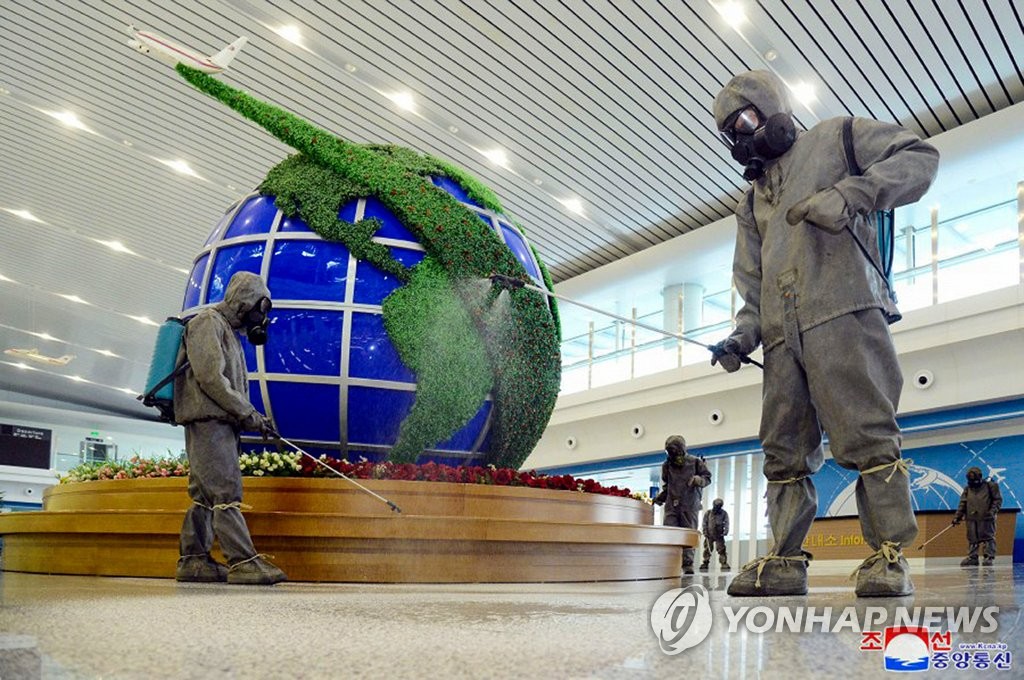 Quarantine officials spray disinfectant at Pyongyang International Airport in the North Korean capital amid the highest-level alert for the coronavirus, in this undated file photo released by the North's Korean Central News Agency on June 10, 2022. (For Use Only in the Republic of Korea. No Redistribution) (Yonhap)