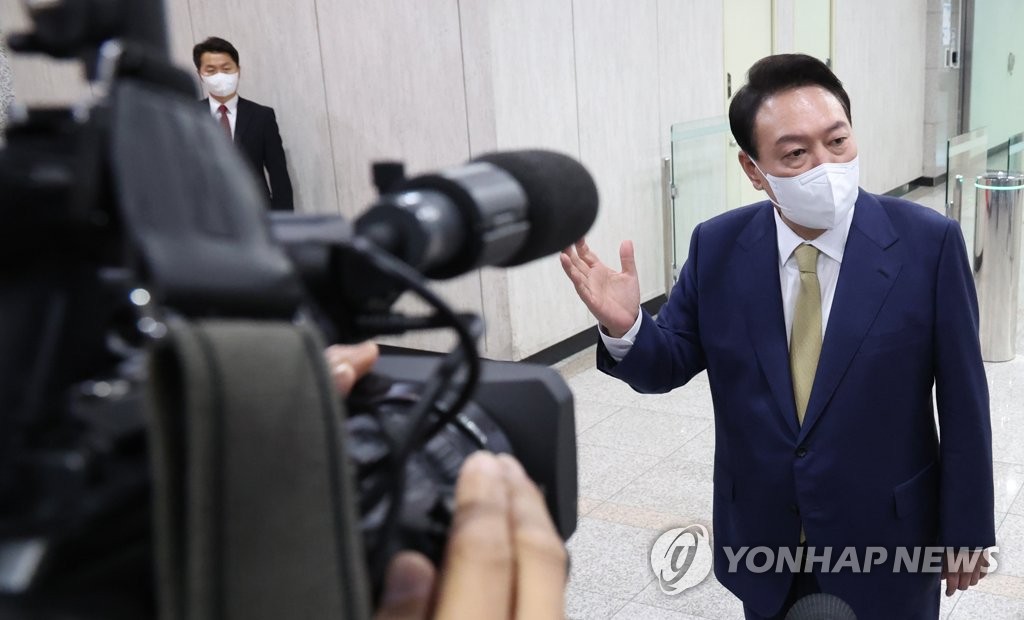 President Yoon Suk-yeol takes reporters' questions as he arrives at the presidential office in Seoul on June 13, 2022. (Yonhap)