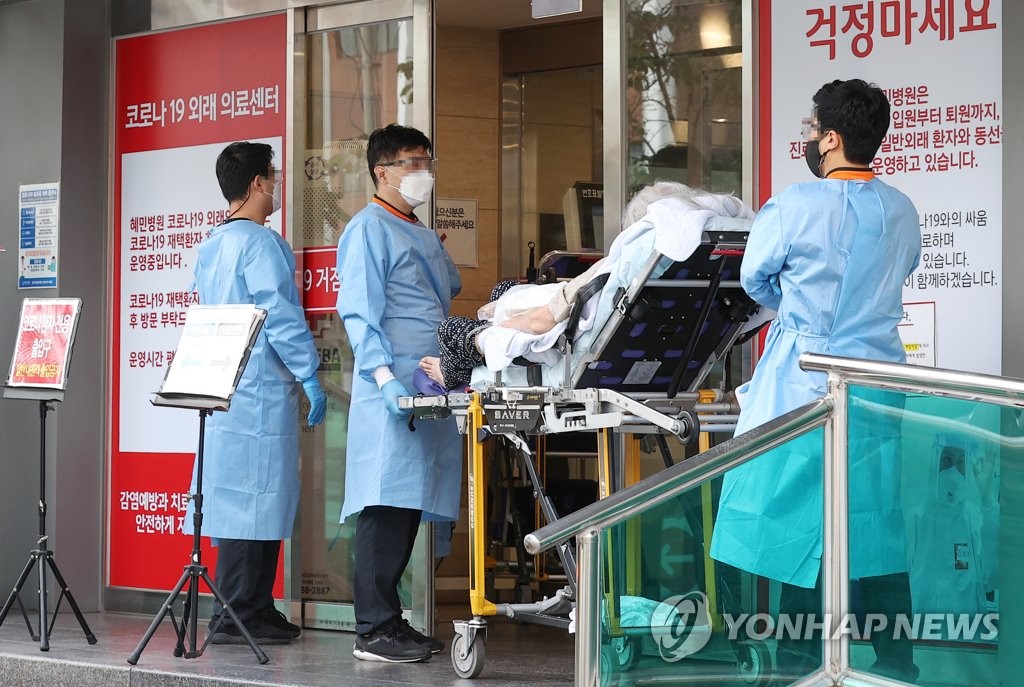 Paramedics carry a COVID-19 patient on a stretcher at a hospital in eastern Seoul on July 26, 2022. (Yonhap) 