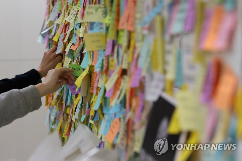People post messages of condolence in front of the ladies' room at Sindang Station in Seoul, where an alleged stalking and murder case recently took place, on Sept. 20, 2022. (Yonhap)