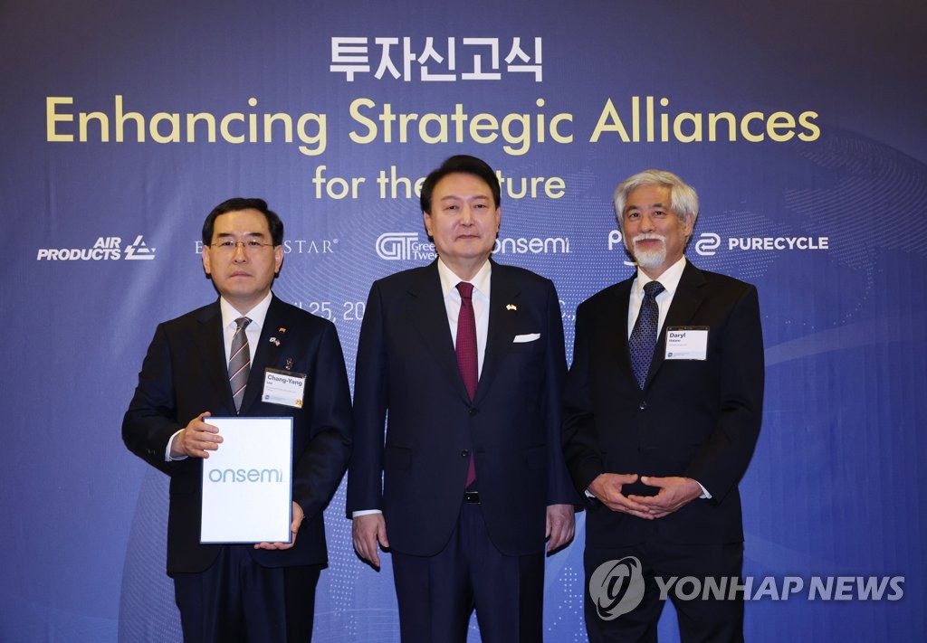 President Yoon Suk Yeol (C) poses for a photo with Industry Minister Lee Chang-yang (L) and onsemi Vice President Daryl Hatano during an investment ceremony at the U.S. Chamber of Commerce in Washington on April 25, 2023. (Yonhap)