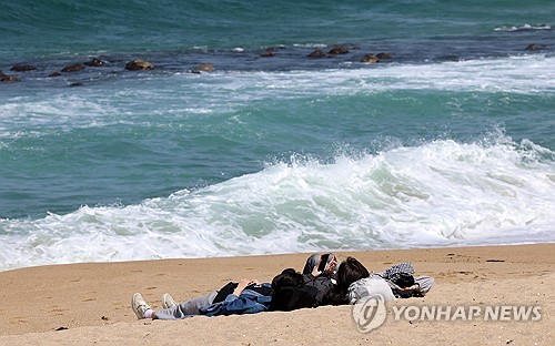 강릉 강문해변 백사장에 누워 바닷바람 즐기는 관광객들