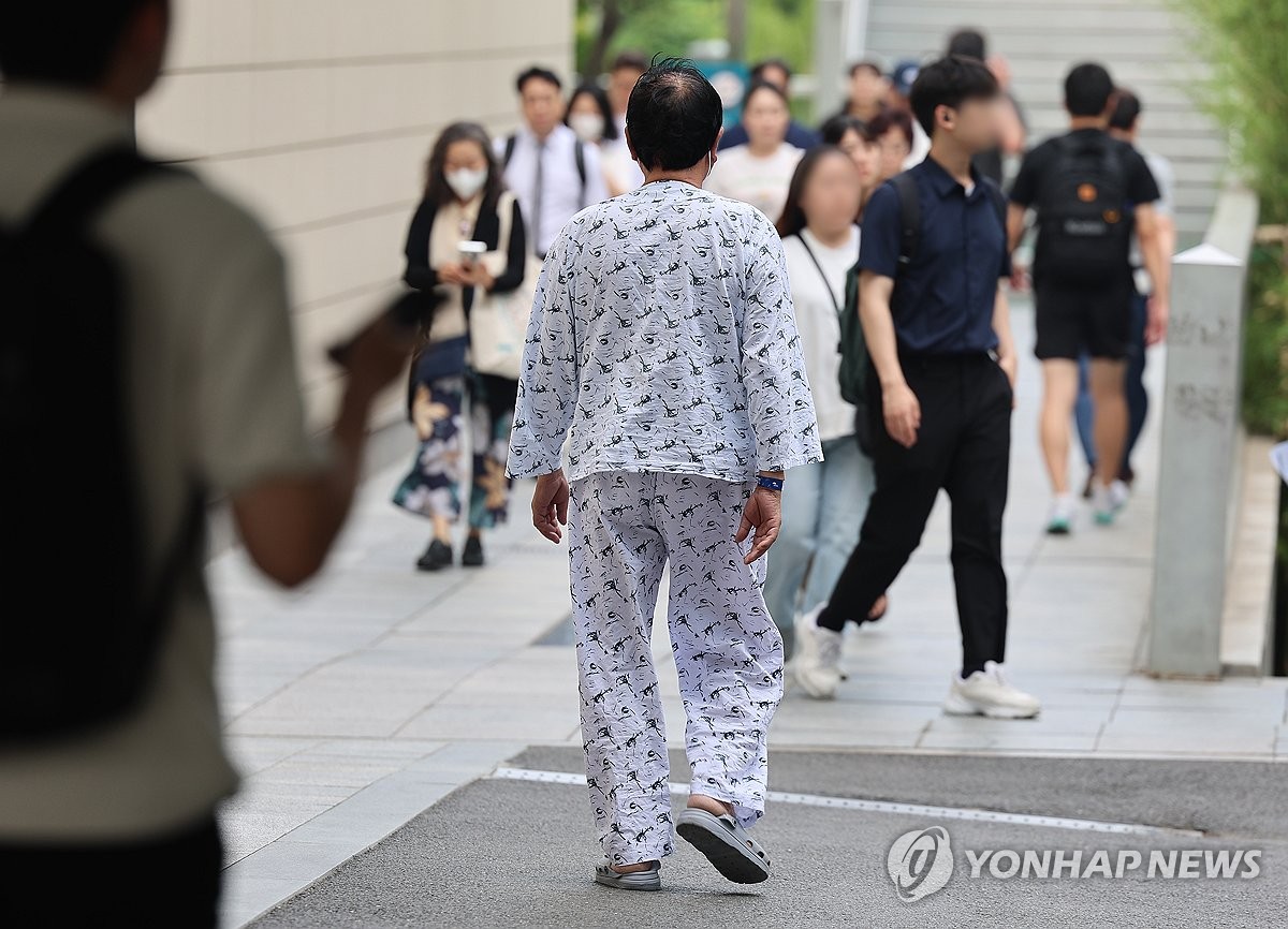 La fotografía, tomada el 11 de junio de 2024, muestra a un paciente caminando por fuera de un hospital, en el centro de Seúl.