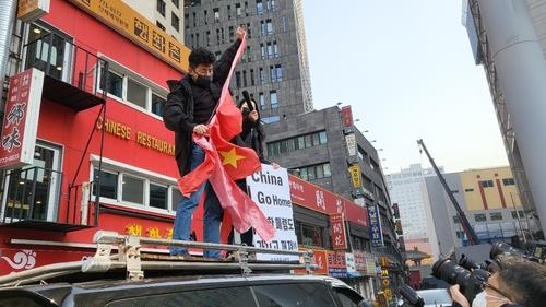 محتجون يمزقون العلم الصيني خلال مسيرة في سيئول حول التحكيم الأولمبي