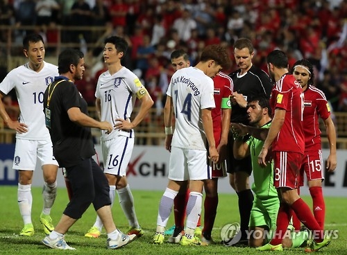 South Korean players (in white) show their frustration as Syrian goalkeeper Ibrahim Alma (in green) stays on the pitch to delay their Asian World Cup qualifying match at Tuanku Abdul Rahman Stadium in Seremban, Malaysia, on Sept. 6, 2016. (Yonhap)