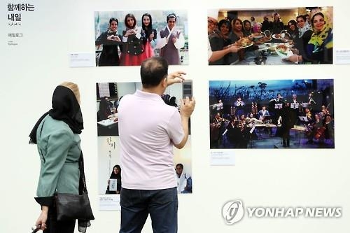 Visitors watch photos on display at a special photo exhibition that marks the long-standing friendship between South Korea and Iran at the National Museum of Korean Contemporary History in Seoul on Sept. 28, 2016. (Yonhap)