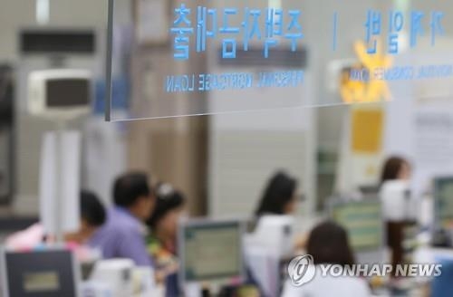 In this undated file photo, customers discuss mortgage loans with bank officials. (Yonhap)