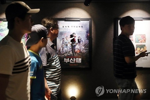 Moviegoers walk past the poster for the Korean action film "Train to Busan" at a Seoul theater on Aug. 7, 2016. (Yonhap)