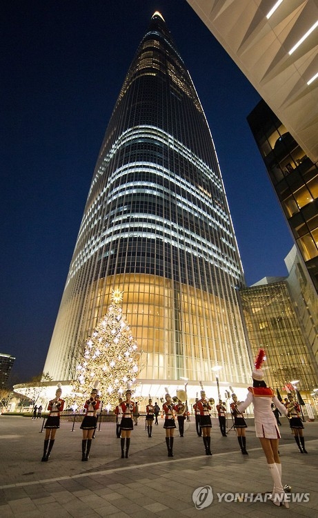 This file photo provided by Lotte on Nov. 4, 2016, shows a marching band playing a Christmas carol the previous day in front of Lotte World Tower. (Yonhap)