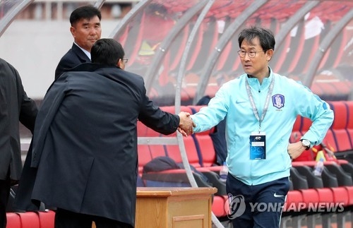 South Korean women's national football team head coach Yoon Duk-yeo (R) shakes hands with North Korean women's national football team head coach Kim Kwang-min before the kickoff the Asian Football Confederation Women's Asian Cup Group B qualifying match between South Korea and North Korea at Kim Il-sung Stadium in Pyongyang on April 7, 2017. (Joint Press Corps) 