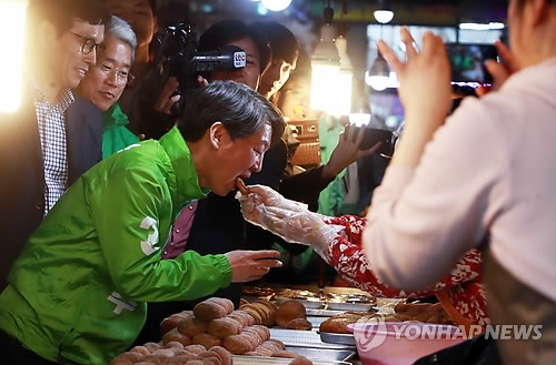 Ahn Cheol-soo, presidential candidate of the People's Party, tastes a donut at a market in Gwangju, 329 kilometers south of Seoul, on April 17, 2017. (Yonhap)