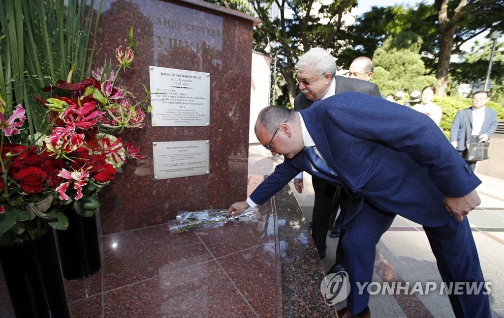 Sergey Mikhaylov, president of Russia's state-run news agency Tass, lays a flower at the base of a statue of the Russian poet Alexander Pushkin in front of Lotte Hotel in central Seoul on June 5, 2017. (Yonhap)