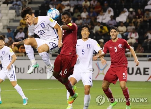 South Korea's Jang Hyun-soo (L) vies for the ball with Qatar's Mohammed Kasola during the FIFA World Cup Asian qualifying match at Jassim Bin Hamad Stadium in Doha on June 13, 2017. (Yonhap)