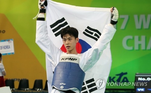 Kim Tae-hun of South Korea lifts his national flag in celebration of his gold medal in the men's under-54kg at the World Taekwondo Federation (WTF) World Taekwondo Championships at Taekwondowon's T1 Arena in Muju, North Jeolla Province, on June 25, 2017. (Yonhap)