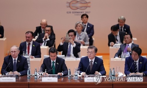South Korean President Moon Jae-in (front row, second from R) attends the first session of the G20 summit in Hamburg, Germany on July 7, 2017. (Yonhap)