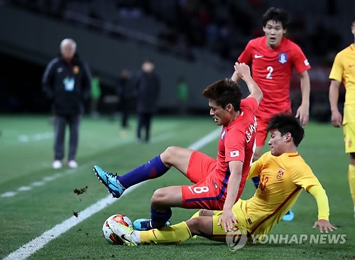 South Korean midfielder Lee Myung-joo (L) is tackled by Chinese midfielder He Chao during the teams' 2-2 draw at the the East Asian Football Federation E-1 Football Championship at Ajinomoto Stadium in Tokyo on Dec. 9, 2017. (Yonhap)