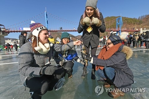 This 2017 file photo shows foreign visitors fishing for "sancheoneo," a type of mountain trout, during the annual Hwacheon Sancheoneo Ice Festival in Hwacheon, 120 kilometers northeast of Seoul. (Yonhap)