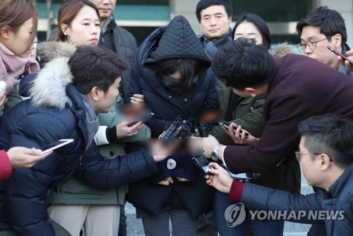 A woman arrested on suspected involvement in disposing the body of a 5-year-old girl named Koh Jun-hee is surrounded by reporters at Deokjin Police Station in Jeonju, North Jeolla Province, on Dec. 31, 2017. (Yonhap). 