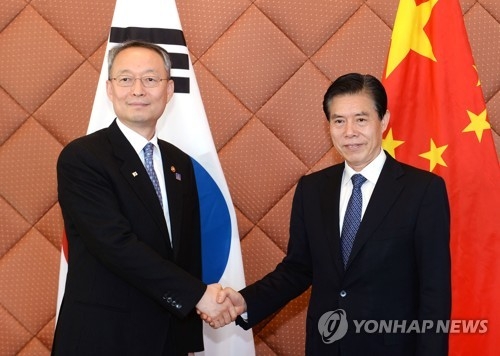 Paik Un-gyu (L), South Korea's minister of trade, industry and energy, meets his Chinese counterpart Zhong Shan (R) in Beijing on Dec. 15, 2017, in this photo provided by his ministry. The two officials agreed to expedite negotiations to expand the two countries' two-year-old free trade agreement to include the service and investment sectors. (Yonhap)