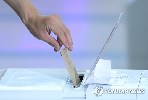 This photo, taken June 8, 2018, shows a voter casting a ballot at a polling center set up at Seoul Station on the first day of early voting for the June 13 local elections and parliamentary by-elections. (Yonhap)