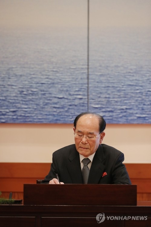 North Korea's nominal head of state Kim Yong-nam writes in the visitor's book at Cheong Wa Dae in Seoul on Feb. 10, 2018. (Yonhap) 