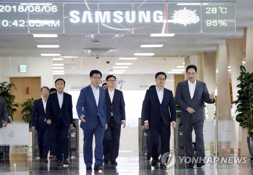 Finance Minister Kim Dong-yeon (2nd from R) talks with Samsung Electronics Vice Chairman Lee Jae-yong while moving into a room for talks at the tech giant's chipmaking line in Pyeongtaek, south of Seoul, on Aug. 6, 2018. (Yonhap)