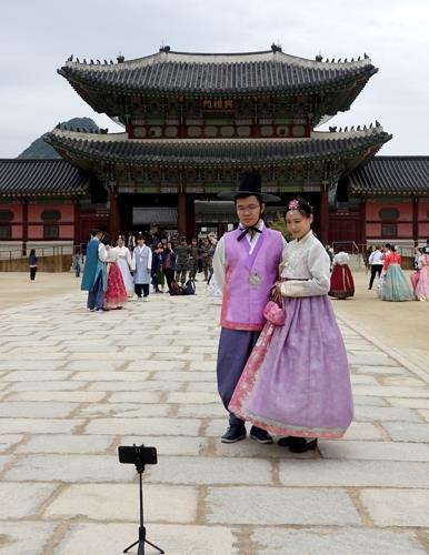 This file photo shows foreign tourists clad in rented "hanbok," or the traditional Korean attire, taking a picture at Gyeongbok Palace in Seoul on April 22, 2018. The palace, one of the royal residences from the Joseon Dynasty (1392-1910), is a top tourist spot in the South Korean capital. (Yonhap)