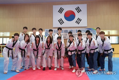 South Korean taekwondo practitioners pose for photos during a media day event at the Jincheon National Training Center in Jincheon, 90 kilometers south of Seoul, on Aug. 8, 2018. (Yonhap)